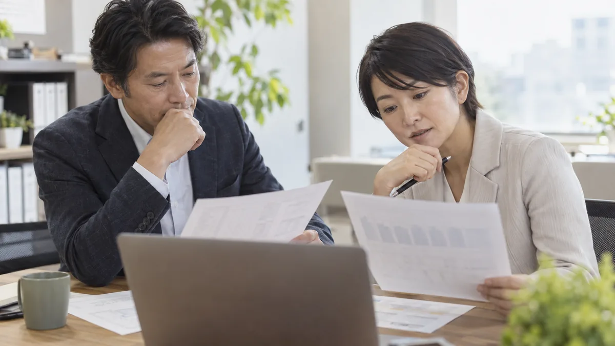 経営者と管理職が評価や賃金の資料を確認するイメージ